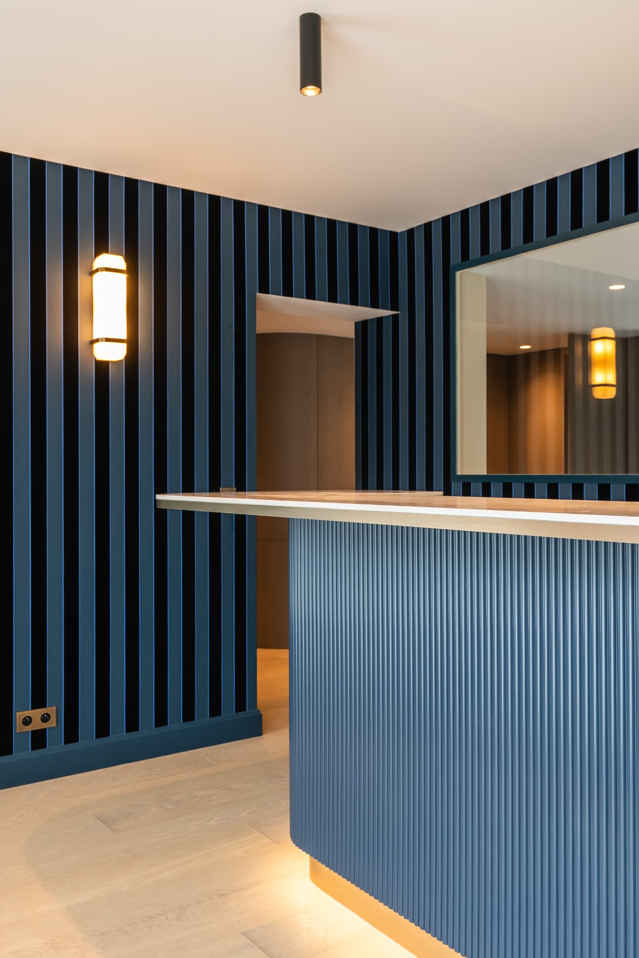 Bar bleu cannelé et applique opaline, maison de bord de mer en Normandie