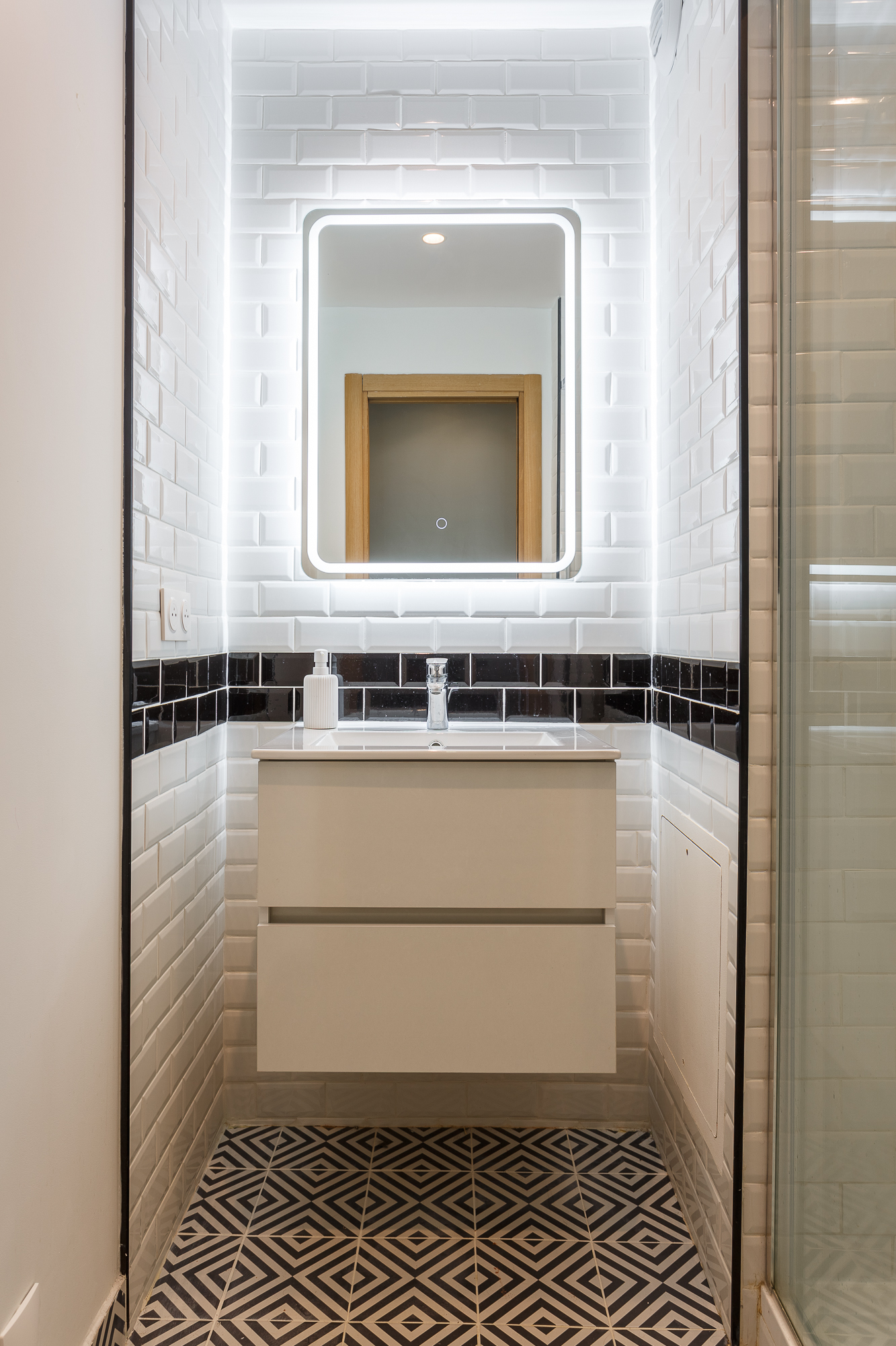 Salle de bains en carrelage métro avec miroir rétroéclairé, appartement Paris 17