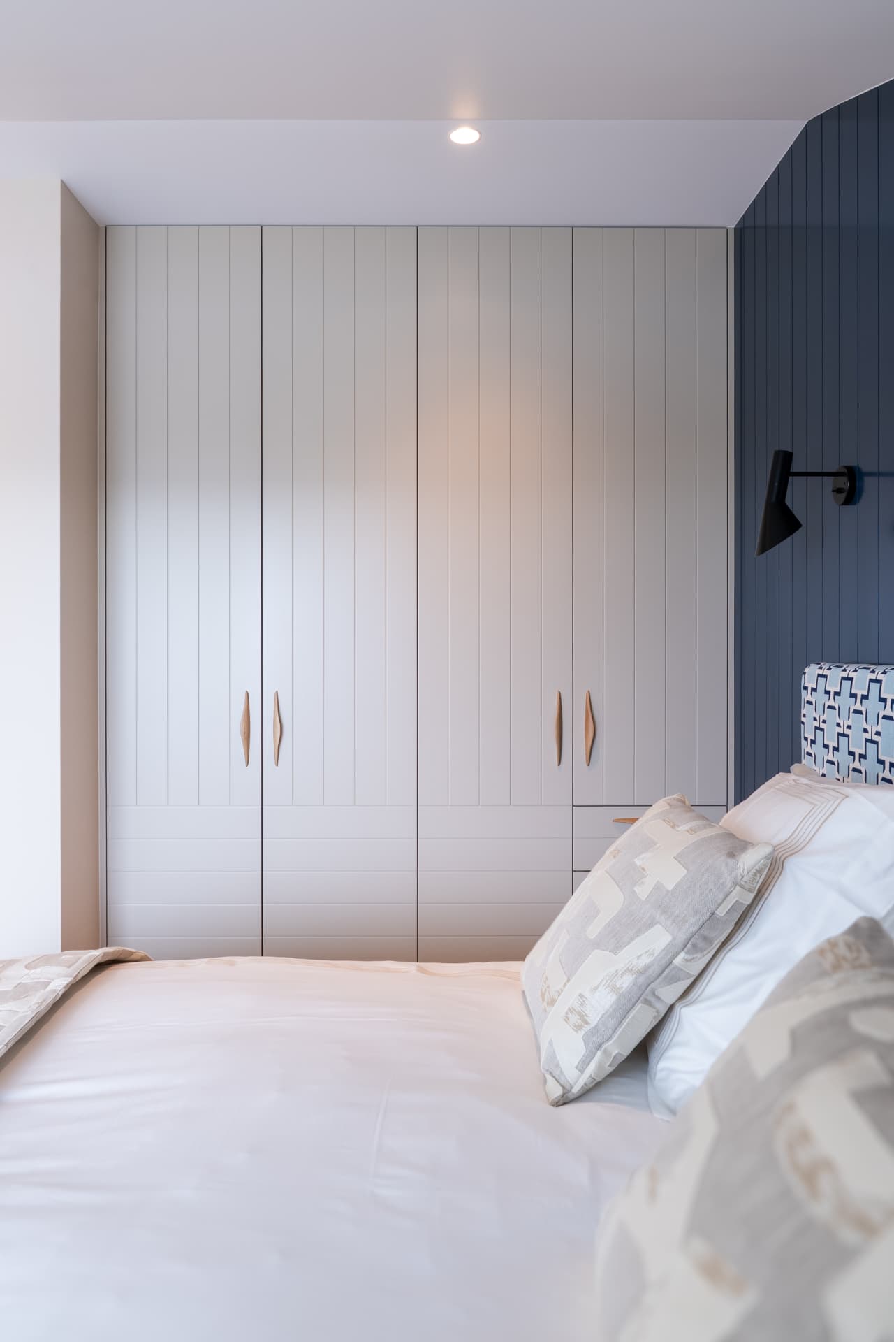 Chambre avec dressing blanc et mur à tasseaux bleu, maison de bord de mer en Normandie