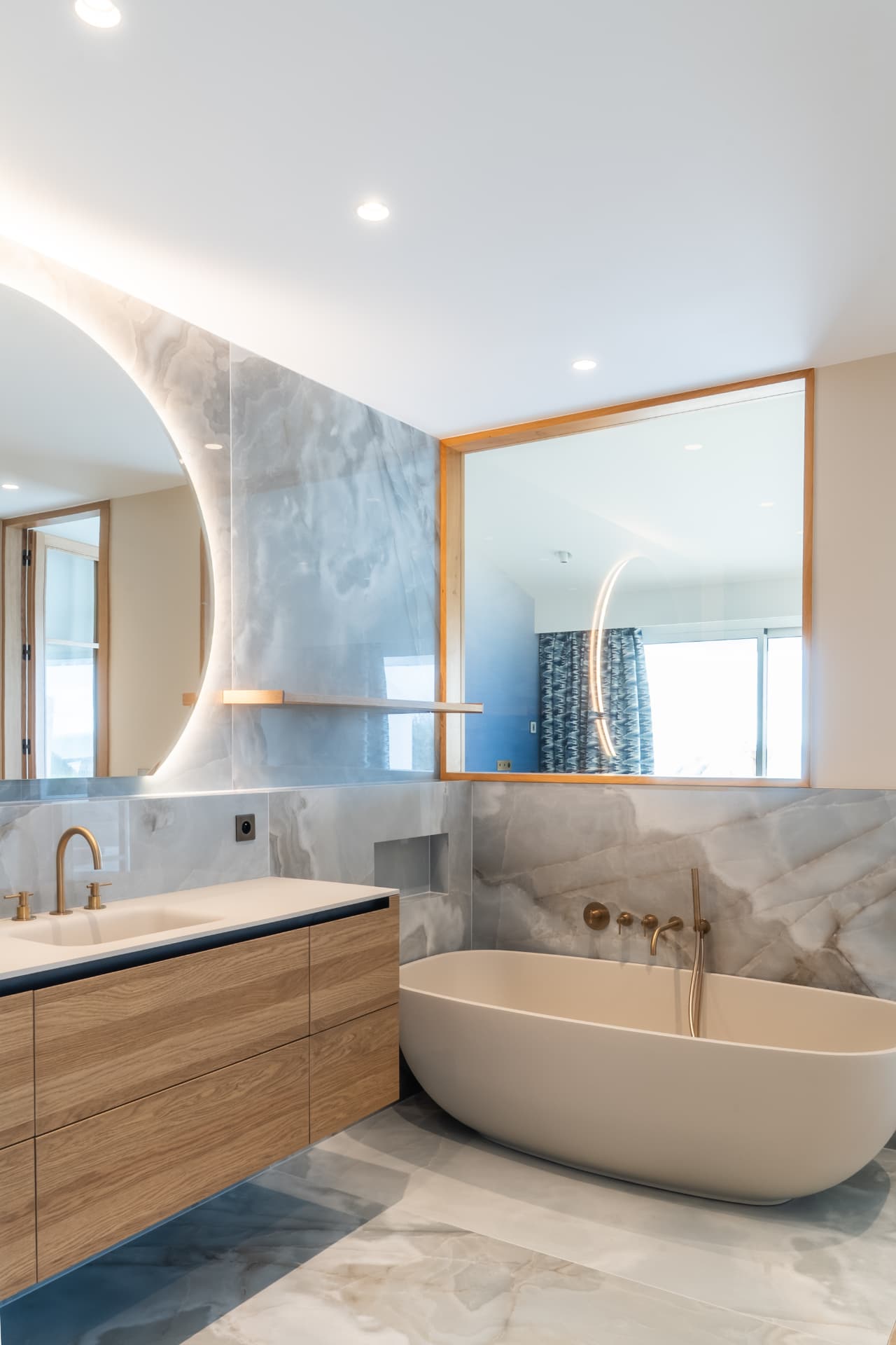 Salle de bains en pierre claire avec baignoire îlot, maison de bord de mer en Normandie