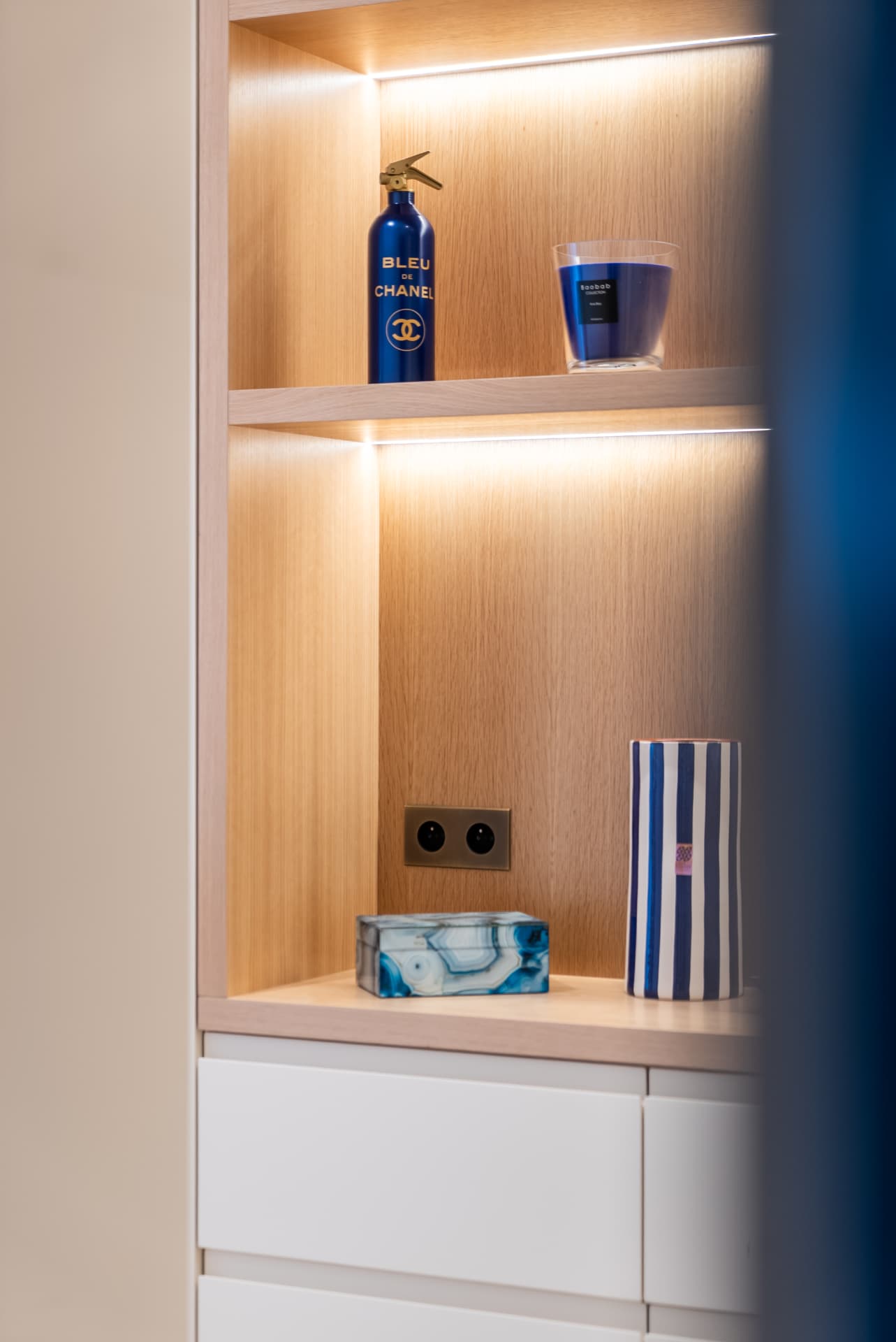 Niche en chêne rétroéclairée et objets décoratifs bleus, maison de bord de mer en Normandie