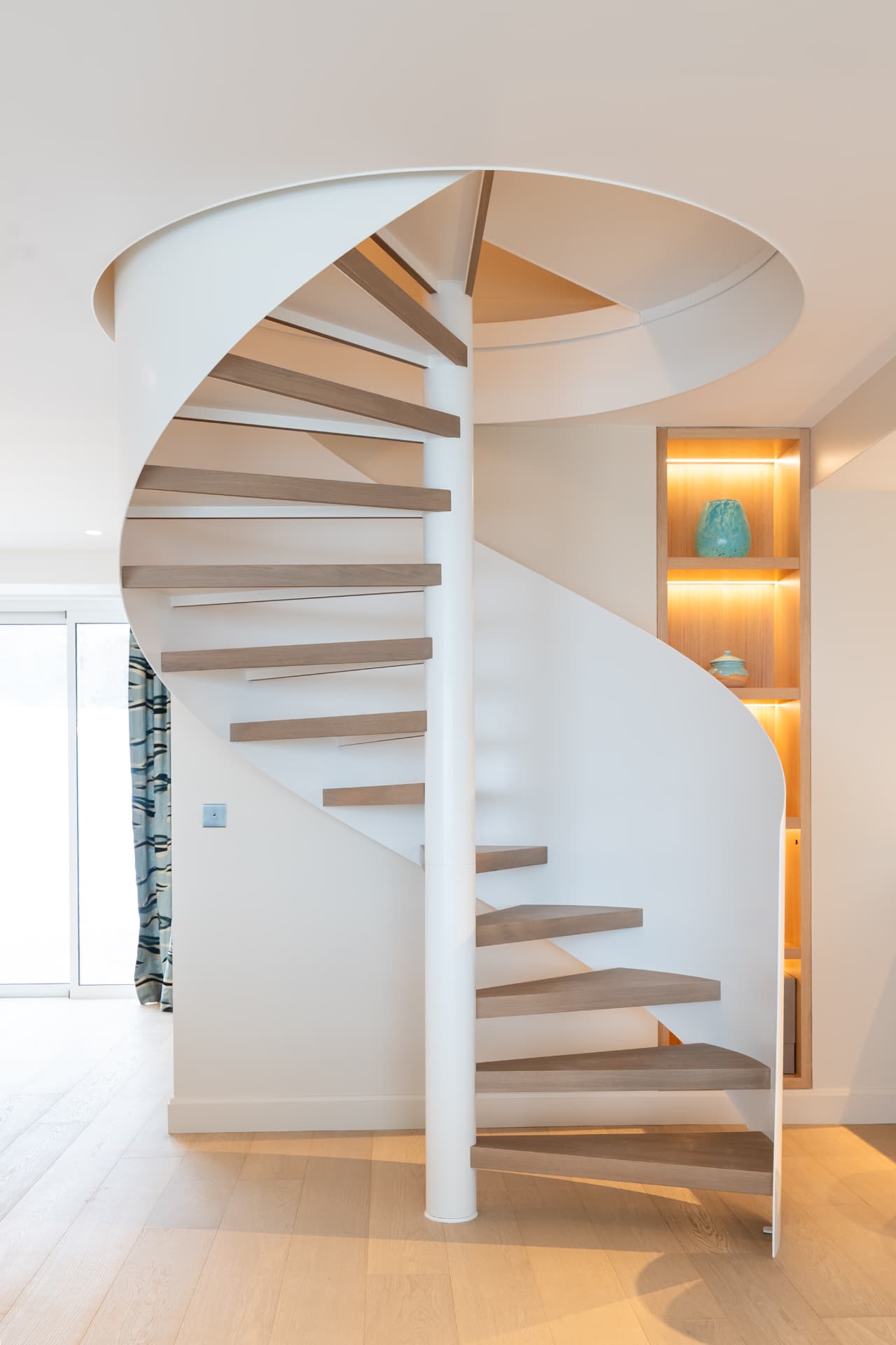 Escalier hélicoïdal blanc à marches en chêne, maison de bord de mer en Normandie